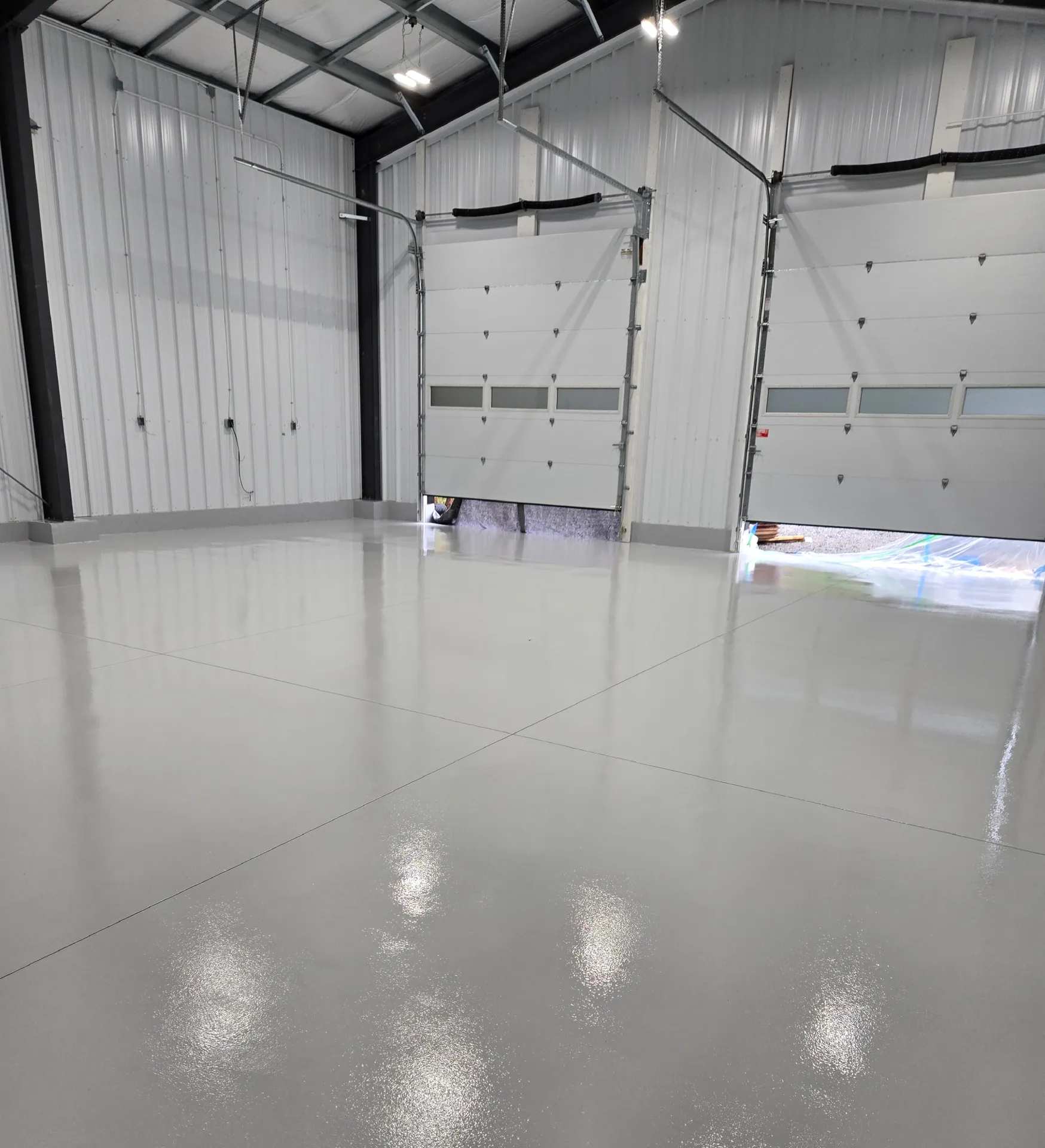 Gloss light grey commercial floor through a Burlington workshop aisle