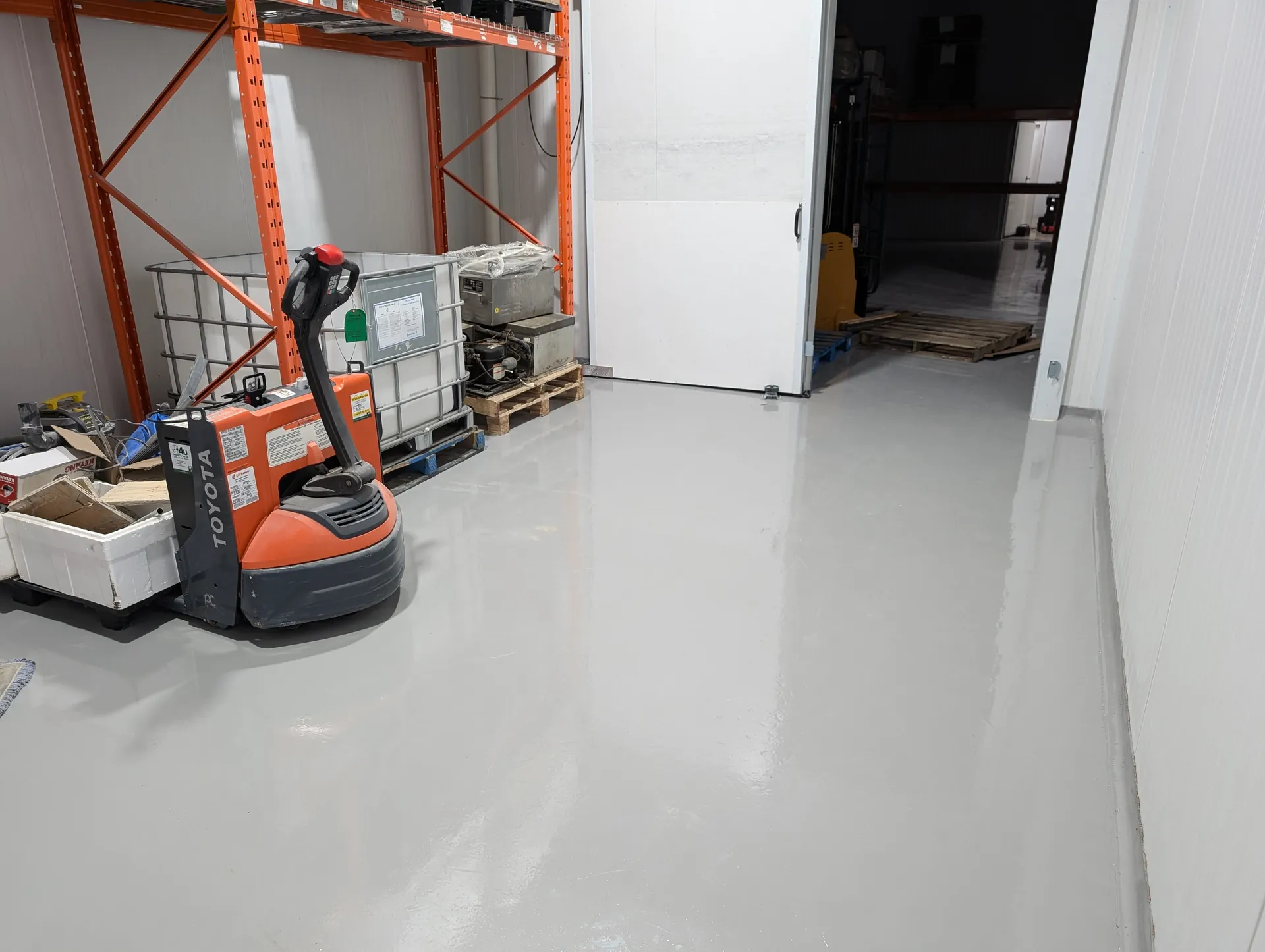 Gloss-coated warehouse floor beside material-handling equipment in Mississauga