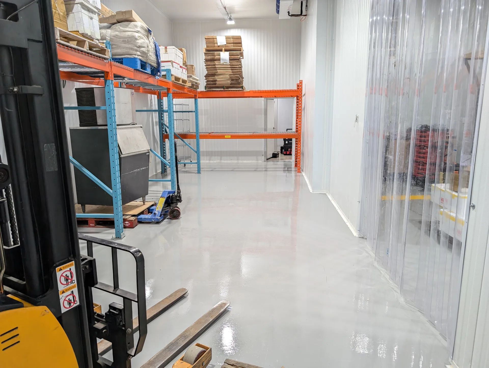 Gloss industrial floor through a warehouse storage aisle