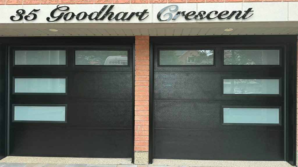 Black double garage doors on a brick home