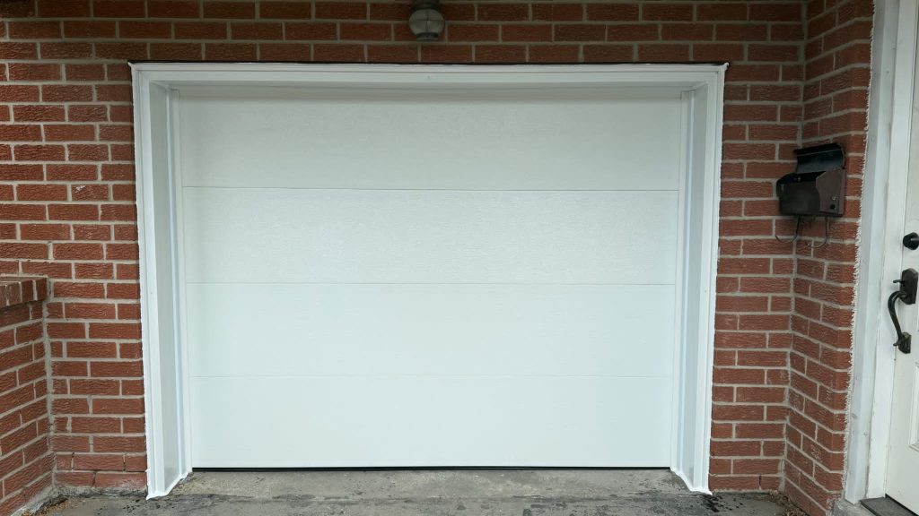 White single garage door set into a brick entry
